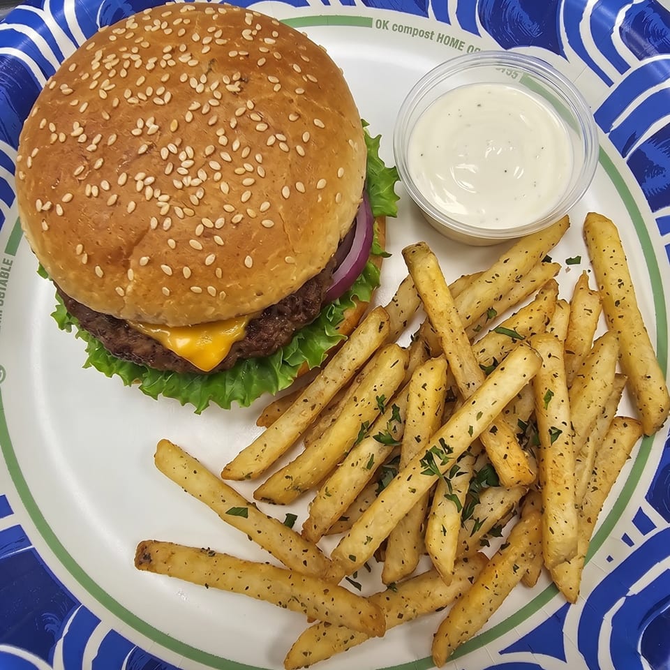 Cheeseburger with lettuce, onion, and sesame seed bun, served with seasoned fries and dipping sauce.