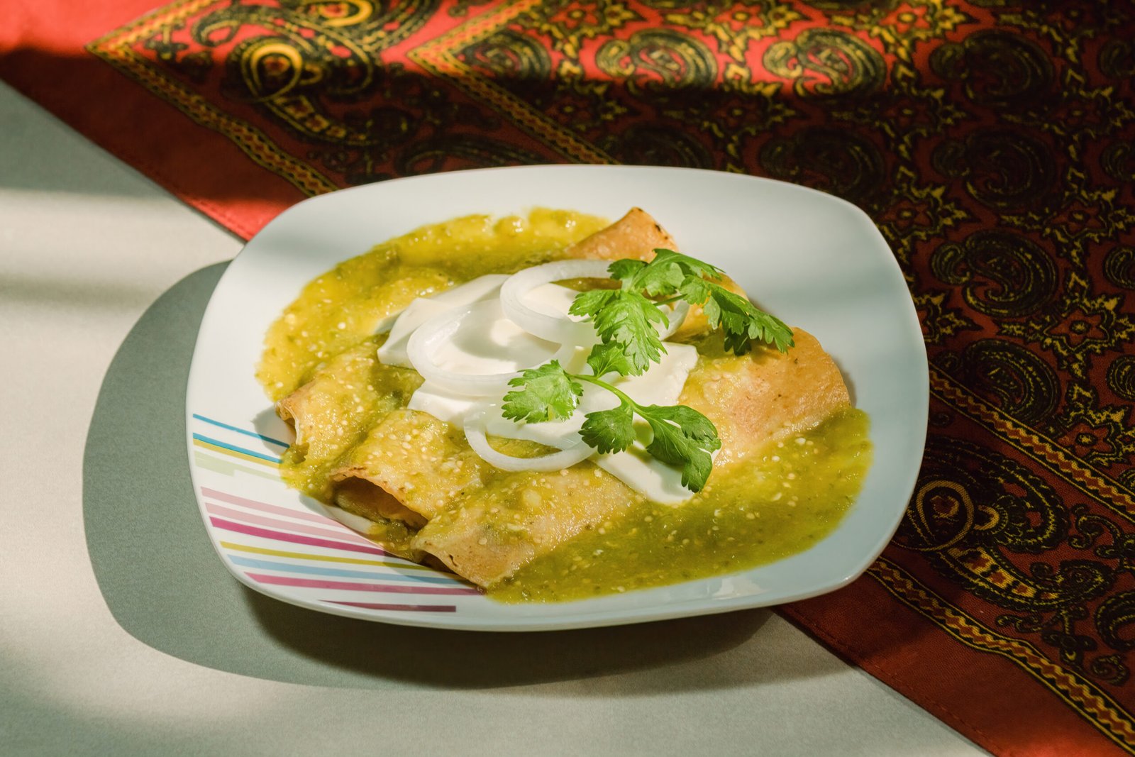 Mexican enchiladas verdes, a staple food in Mexican cuisine, are served on a plate
